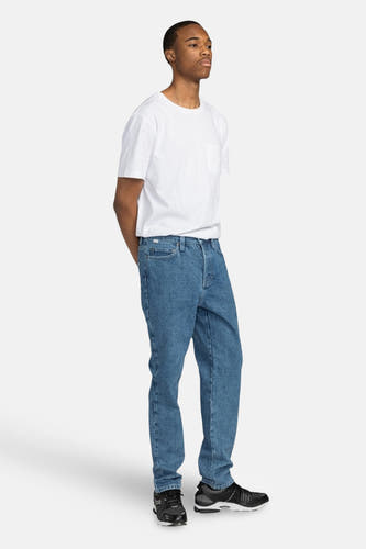 Jean droit en denim bleu, d'ELEMENTMENT avec un T-shirt blanc et des baskets noires.