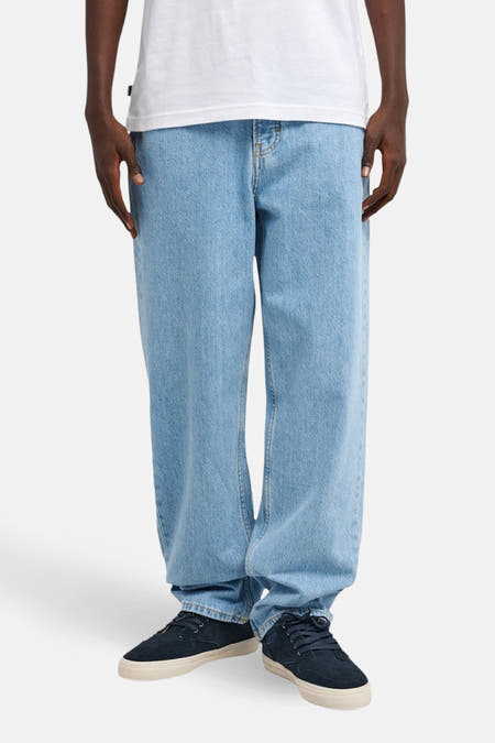 Jean bleu clair et large d'ELEMENT, avec un lavage subtil et associé à des baskets bleu foncé.