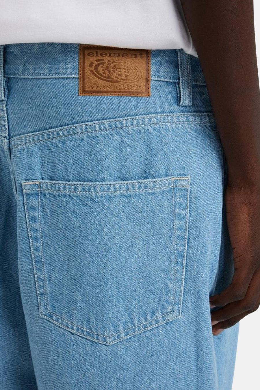 Jean bleu clair large d'Element, avec un poche arrière et une étiquette en cuir marron sur la ceinture.