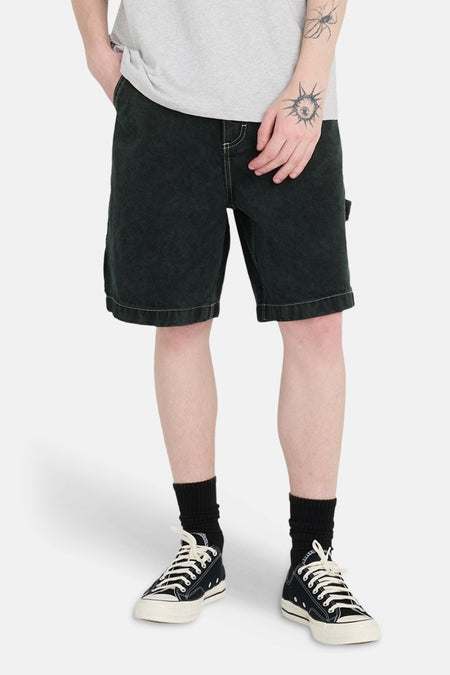 Groene jeansshort van ELEMENT, met opvallende stiksels en gecombineerd met zwarte sokken en canvas schoenen.