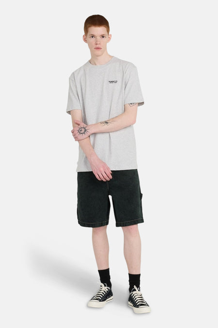Groene jeansshort van ELEMENT, met zwarte sokken en zwart-witte canvas schoenen.
