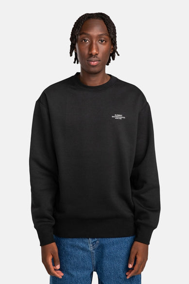 Pull-over noir d'ELEMENT avec un petit logo imprimé, associé à un jean.