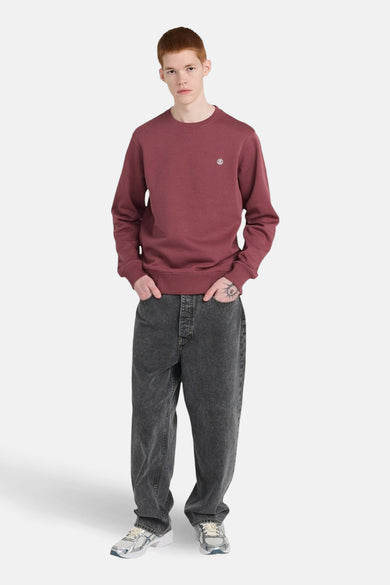 Pull-over rose avec col rond d'ELEMENTE, un petit petit sur la poitrine, porté avec un jeans gris et des baskets.