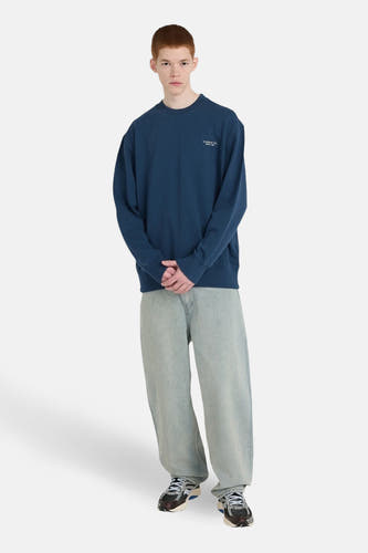 Blauwe sweater van ELEMENT, met losse pasvorm, gecombineerd met wijde jeans en sneakers.
