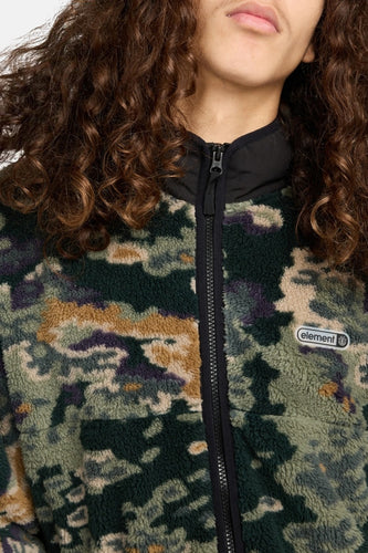 Close-up van iemand in een camouflage fleece jack met een zwarte rits en een "element" logo.