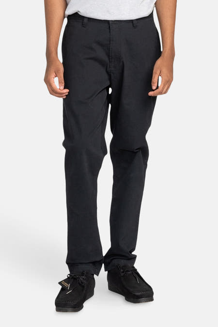 Zwarte chino van ELEMENT, op een model, met zwarte suède schoenen.