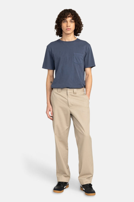 Beige chino van Element, gedragen met een blauw T-shirt en zwarte sneakers.
