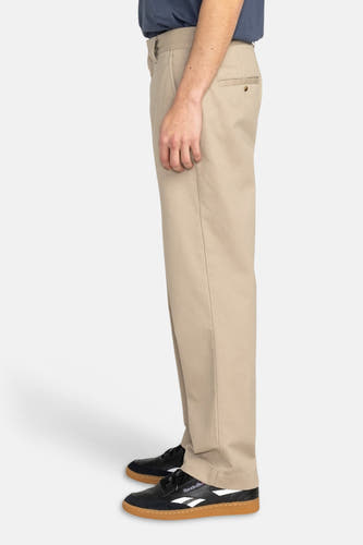 Beige chino van ELEMENT, met achterzak en gedragen met zwarte schoenen.
