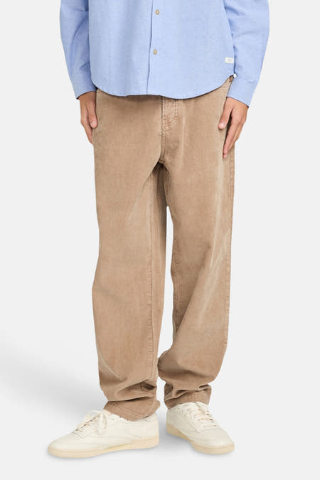 Beige broek van ELEMENT, met een losse pasvorm en gecombineerd met een lichtblauw overhemd en crèmekleurige sneakers.