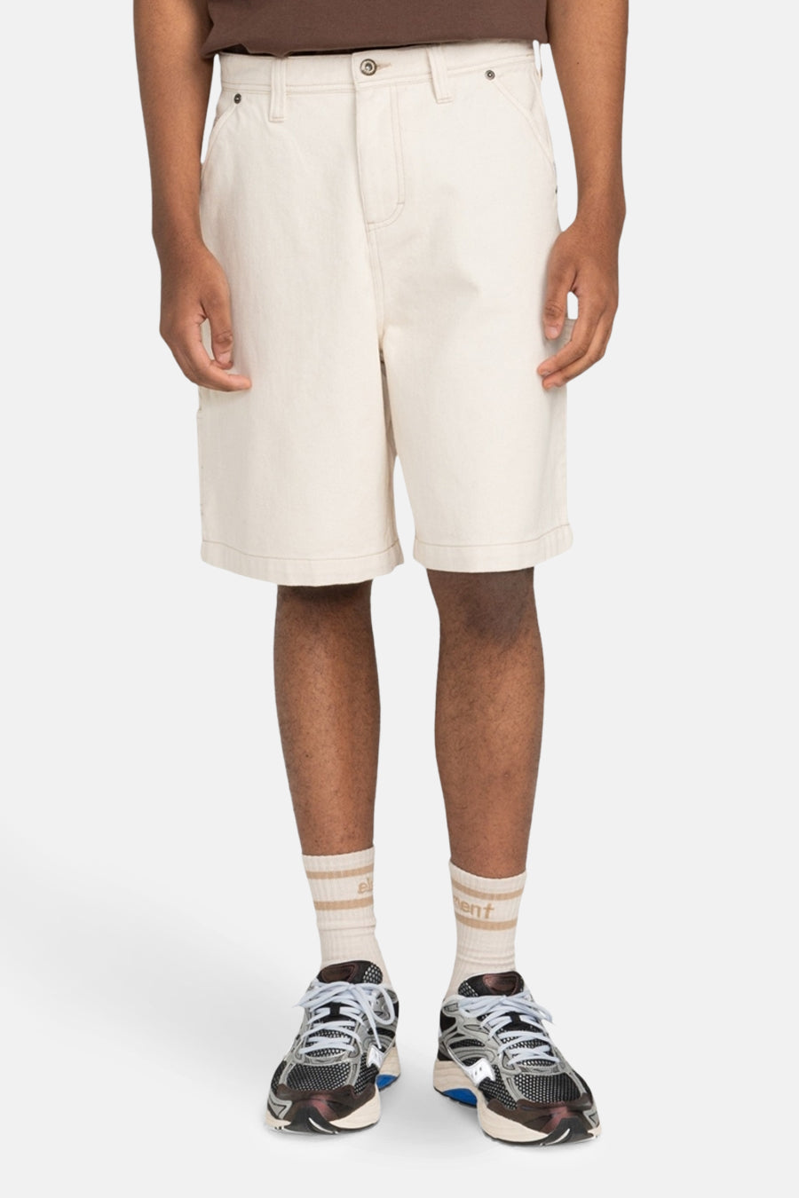 Short écru de ELEMENT, avec des chaussettes rayées beige et des sneakers sombres.