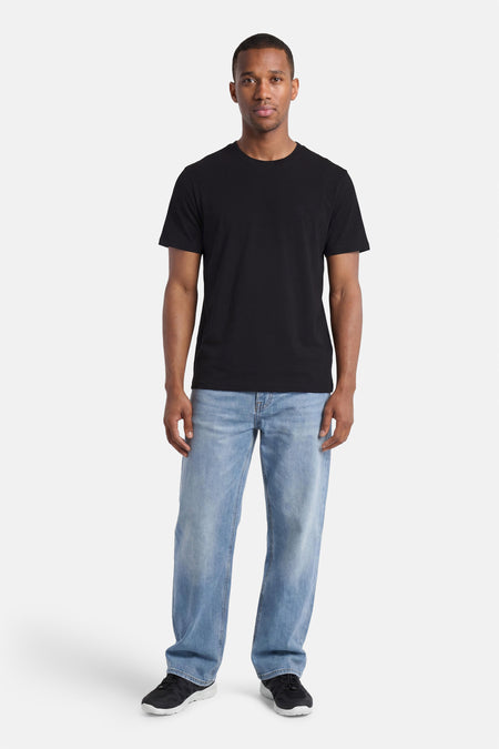 Zwart T-shirt van ELEMENT met subtiel logo op de borst, gedragen door een man met lichte spijkerbroek en zwarte sneakers.