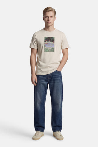 Beige T-shirt met korte mouwen van ELEMENT, met een grafische print, gecombineerd met jeans en schoenen.
