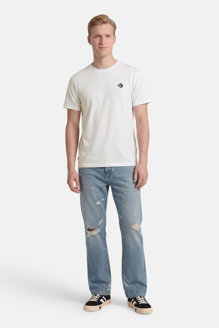 T-shirt blanc à manches courtes de ELEMENT, avec logo brodé sur la poitrine, porté par un homme en jean déchiré et baskets.