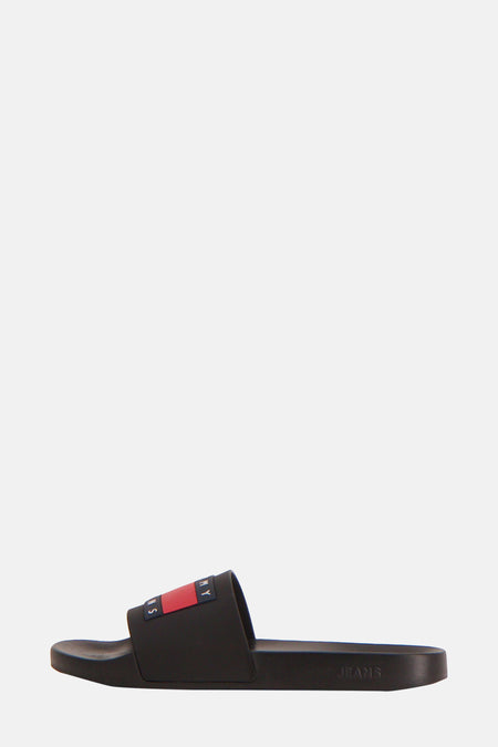 Zwarte slippers van Tommy Jeans met logo op de band in rode, witte en blauwe kleuren.
