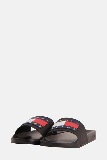 Zwarte slippers van TOMMY JEANS, met rood-wit logo-detail op de band.
