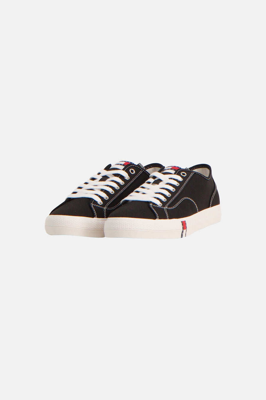 Zwarte sneakers van TOMMY JEANS met witte veters en een contrasterende witte zool met een subtiel logo.
