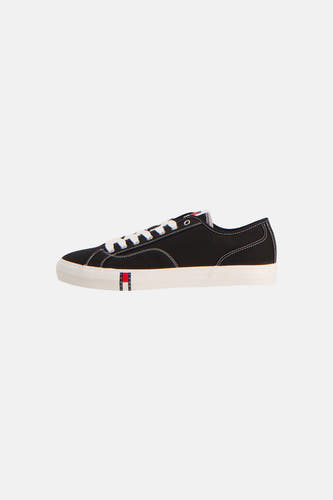 Zwarte sneakers van TOMMY JEANS, met witte veters en zool, en logo op de zijkant.