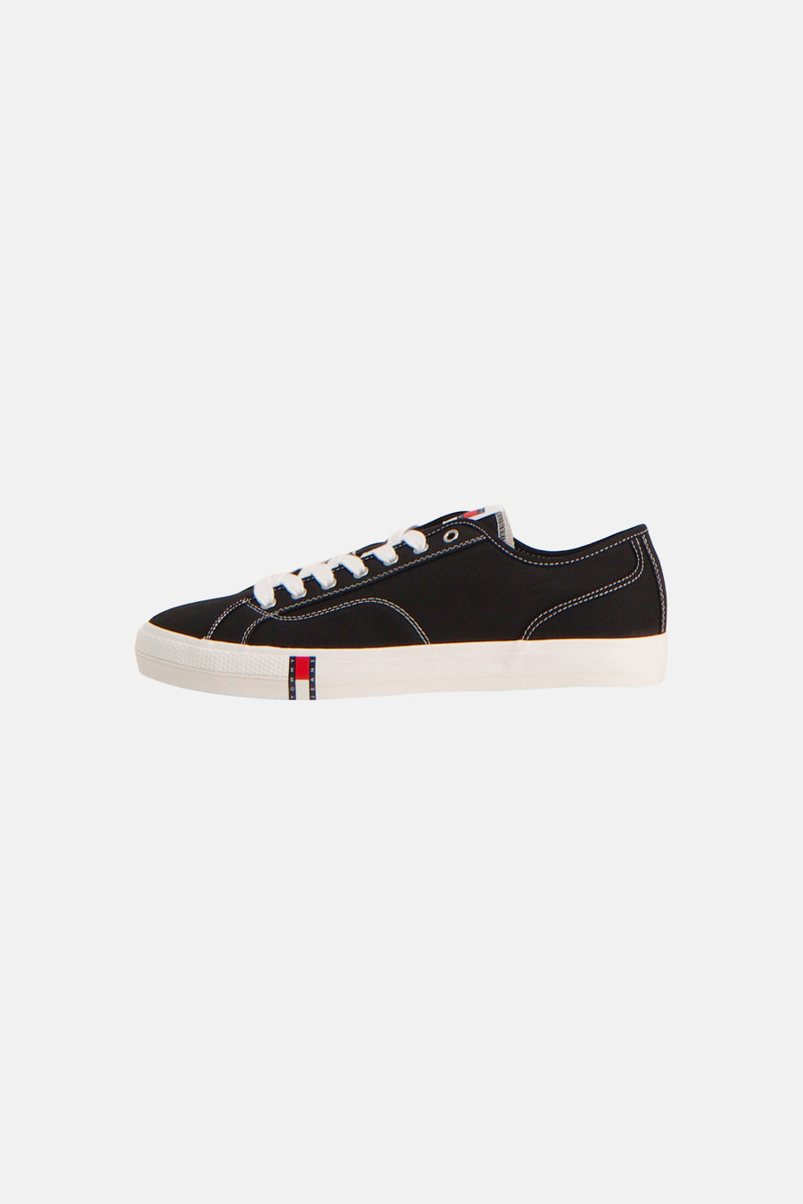 Zwarte sneakers van TOMMY JEANS, met witte veters en zool, en logo op de zijkant.