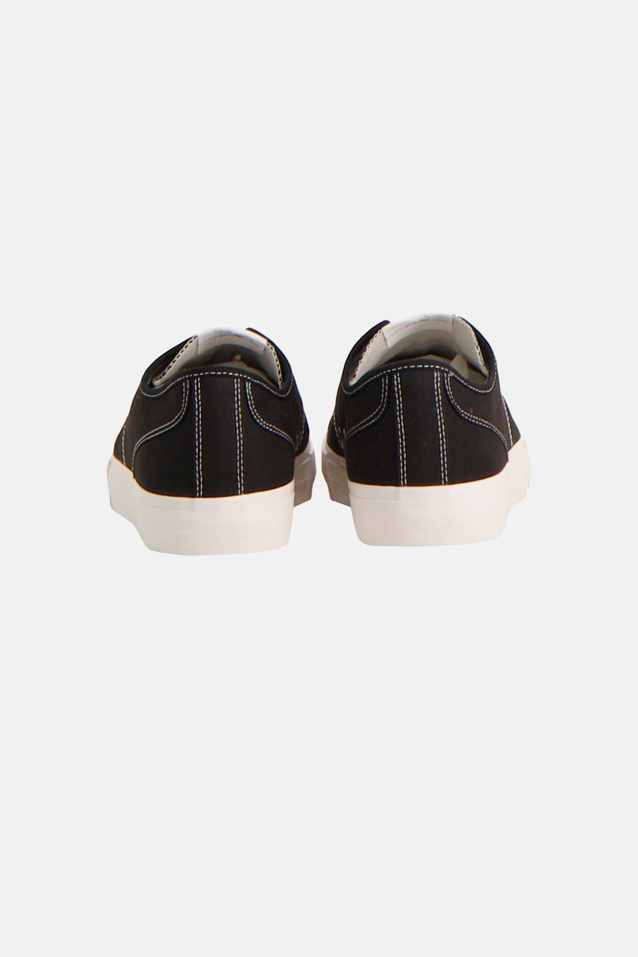 Zwarte sneakers van TOMMY JEANS, met witte zolen en stiksels, gezien van achteren.
