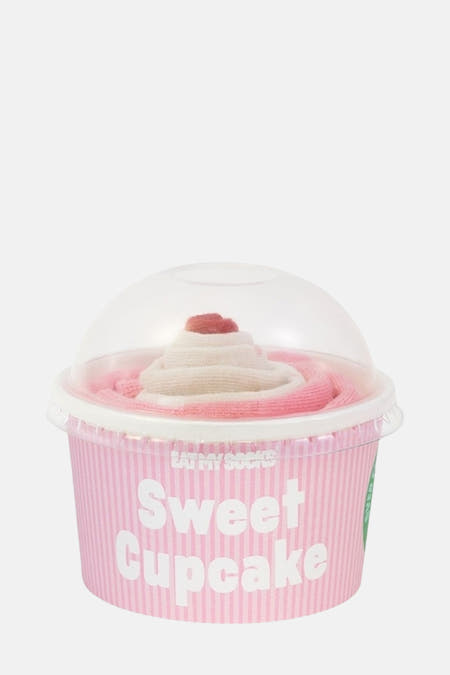 Chaussettes roses dans une boîte à cupcake d'EAT MY SOCKS, empilées comme de la crème fouettée avec un glaçage sur le dessus.