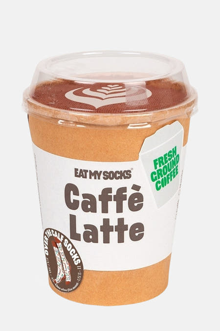 Meerkleurige sokken van EAT MY SOCKS, in een koffiebeker met opschrift "Caffè Latte" en decoratief schuimpatroon.
