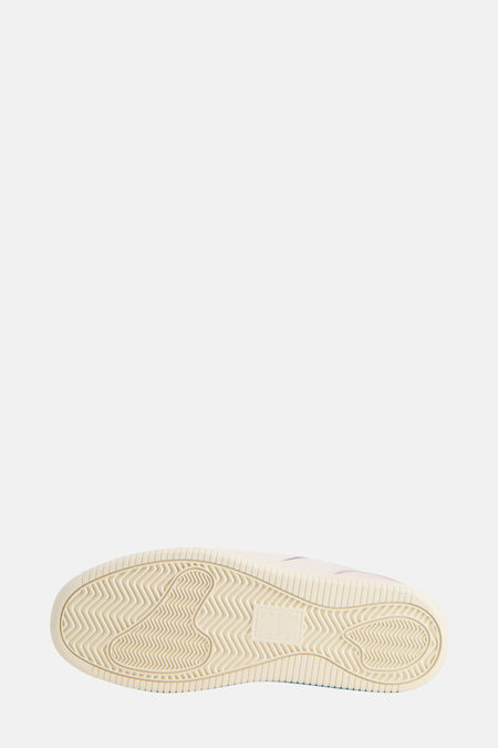 Zool van een crèmekleurige sneaker.