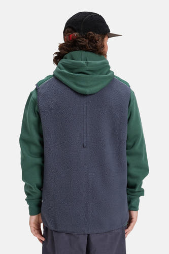 Gilet en polaire bleu de Quiksilver, avec un élément de hoodie vert et une casquette noire.