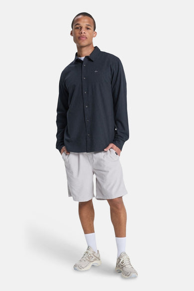 Short gris de Quiksilver, porté avec une chemise à manches longues, des chaussettes et des baskets.