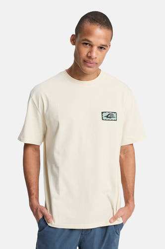 Ecru T-shirt met korte mouwen van Quiksilver, met een logo op de borst en blauwe broek.