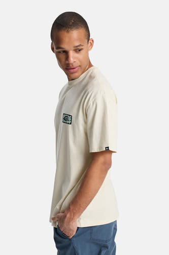 Ecru T-shirt met korte mouwen van Quiksilver, met klein logo op de borst en blauwe broek.