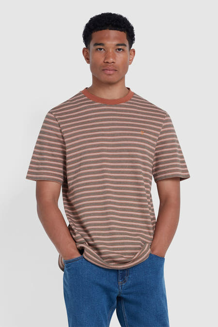Oranje T-shirt met korte mouwen van Farah, met horizontale strepen en gedragen met blauwe jeans.
