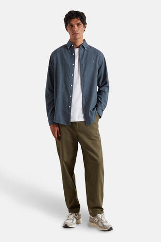 Blau, longsleeve shirt van FARAH, gedragen over een wit T-shirt en met olijfgroene broek en sneakers.