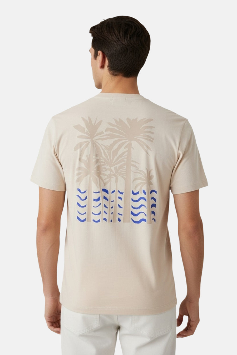 T-shirt beige à manches courtes Guess, avec motif palmier et motifs de vagues bleues au dos.