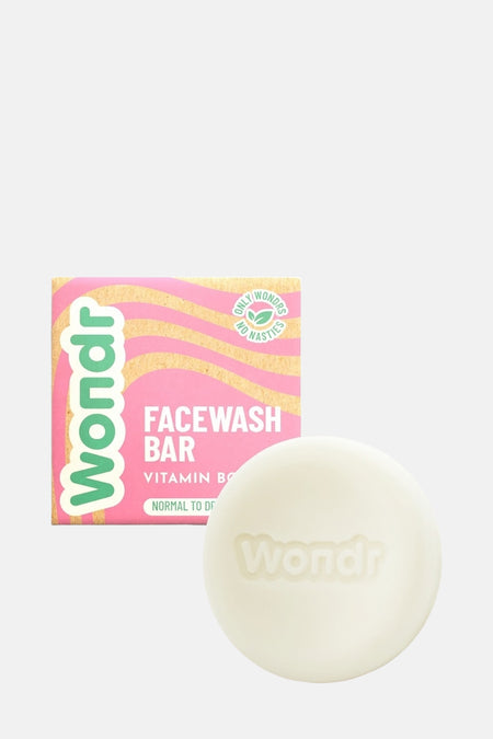 Produit de soin rose de WONDR CARE, une femme se lave le visage avec du savon mousseux.