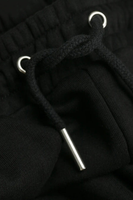 Pantalon de jogging noir FILA avec cordon de serrage tricoté et œillets métalliques argentés, détail en gros plan