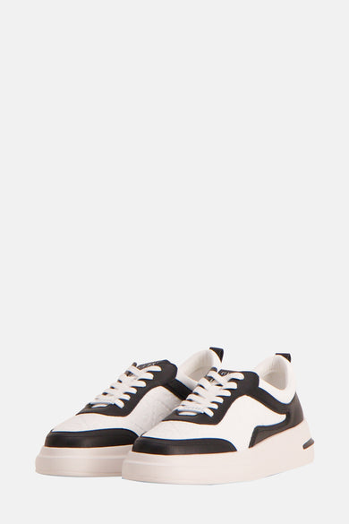 Zwarte sneakers van Guess met witte veters en een dikke zool.

