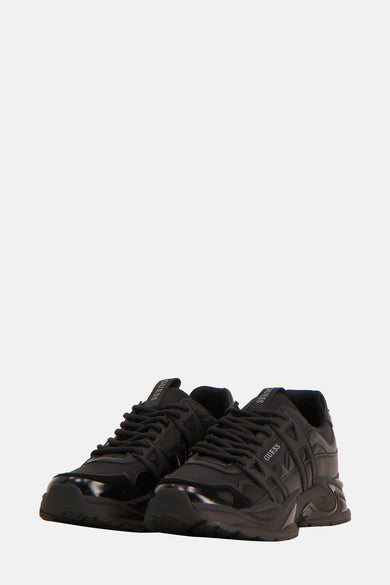 Sneakers noirs de Guess avec une semelle distinctive et le logo Guess visible.
