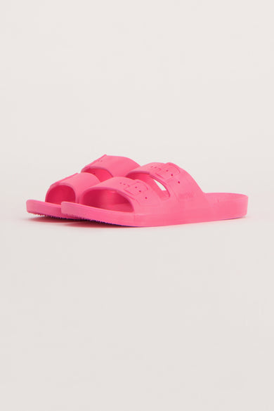 Roze slippers van Freedom Moses, met dubbele band en verstelbare gespen, op een effen achtergrond.
