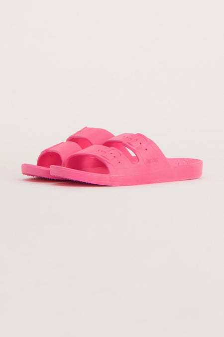 Roze slippers van Freedom Moses, met dubbele band en verstelbare gespen, op een effen achtergrond.
