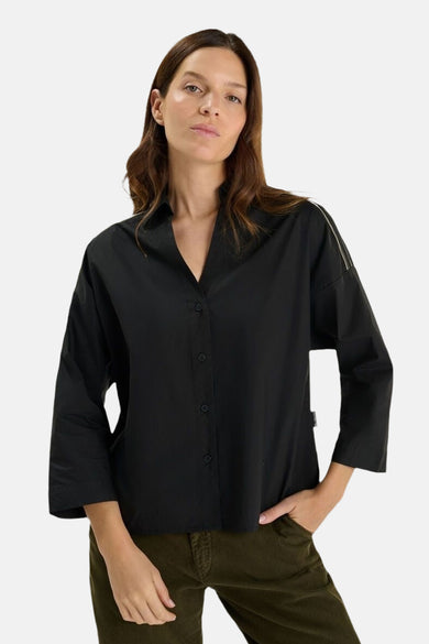 Zwart overhemd met lange mouwen van LE TEMPS DES CERISES, gedragen met een groene broek.
