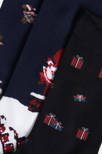 Meerkleurige sokken van FunSocks met kerstthema-ontwerpen, waaronder een kerstman, een cadeau en een hond.