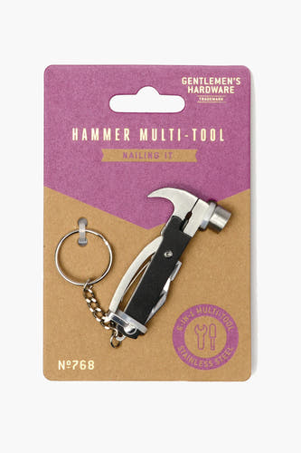 Multicolor geschenk van Gentlemen's Hardware met een mini-hamer multitool en een sleutelhanger, gepresenteerd op een verpakking in paars en bruin karton.
