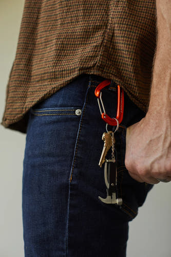 Multicolor geschenk van Gentlemen's Hardware, bevestigd aan een donkerblauwe jeans met een oranje karabijnhaak.
