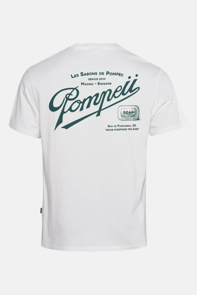 Ecru T-shirt met korte mouwen van POMPEII, met groene "Les Sabons de Pompeii" print op de achterkant.
