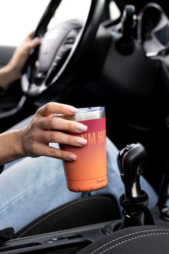 Multicolor geschenk van FISURA, vastgehouden in een auto interieur naast een versnellingspook.