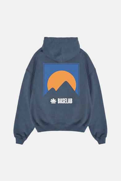 Sweat à capuche bleu de BASELAB, avec paysage de montagne et logo au dos.