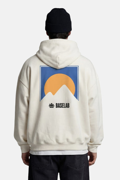 Witte sweater met kap van BASELAB, met grafische print van bergen en de zon op de rug.
