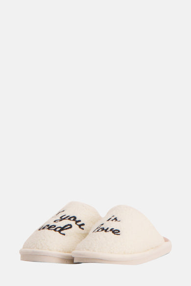 Ecru pantoffels van FISURA met 'If you need is love' tekst en een zachte textuur.
