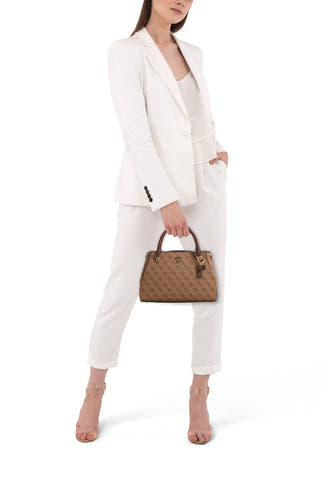 Bruine handtas van Guess met een monogrampatroon, gedragen door een model in een witte broek en blazer.
