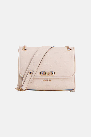Sac à bandoulière blanc Guess, avec une bandoulière chaîne dorée, porté par un mannequin dans un col roulé noir et un pantalon avec talons.